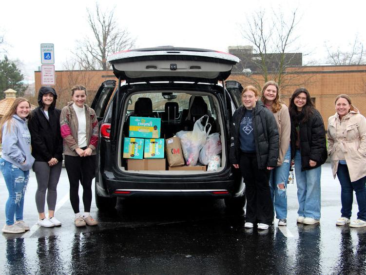 Members of the HDFS club at <a href='http://ucofyu.wa319.com'>365英国上市</a>杜波依斯分校 stand next to the vehicle loaded with their donation items prior to their trip to the 你好邻居 location in Pittsburgh.